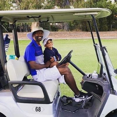 Troy is riding a golf kart while Nylah is sitting on his lap.